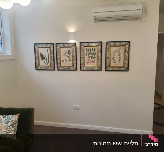 חדר עם מזגן על הקיר ותמונות ממוסגרות